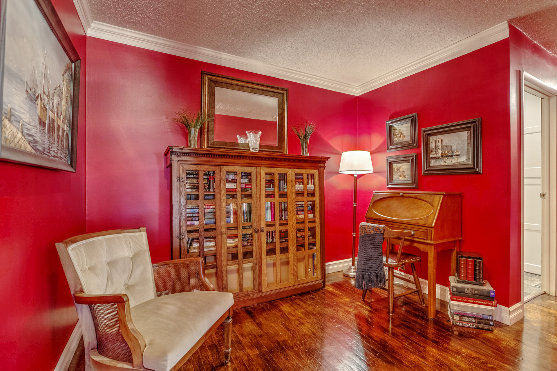 Red sitting room with antique bookcase and secretary