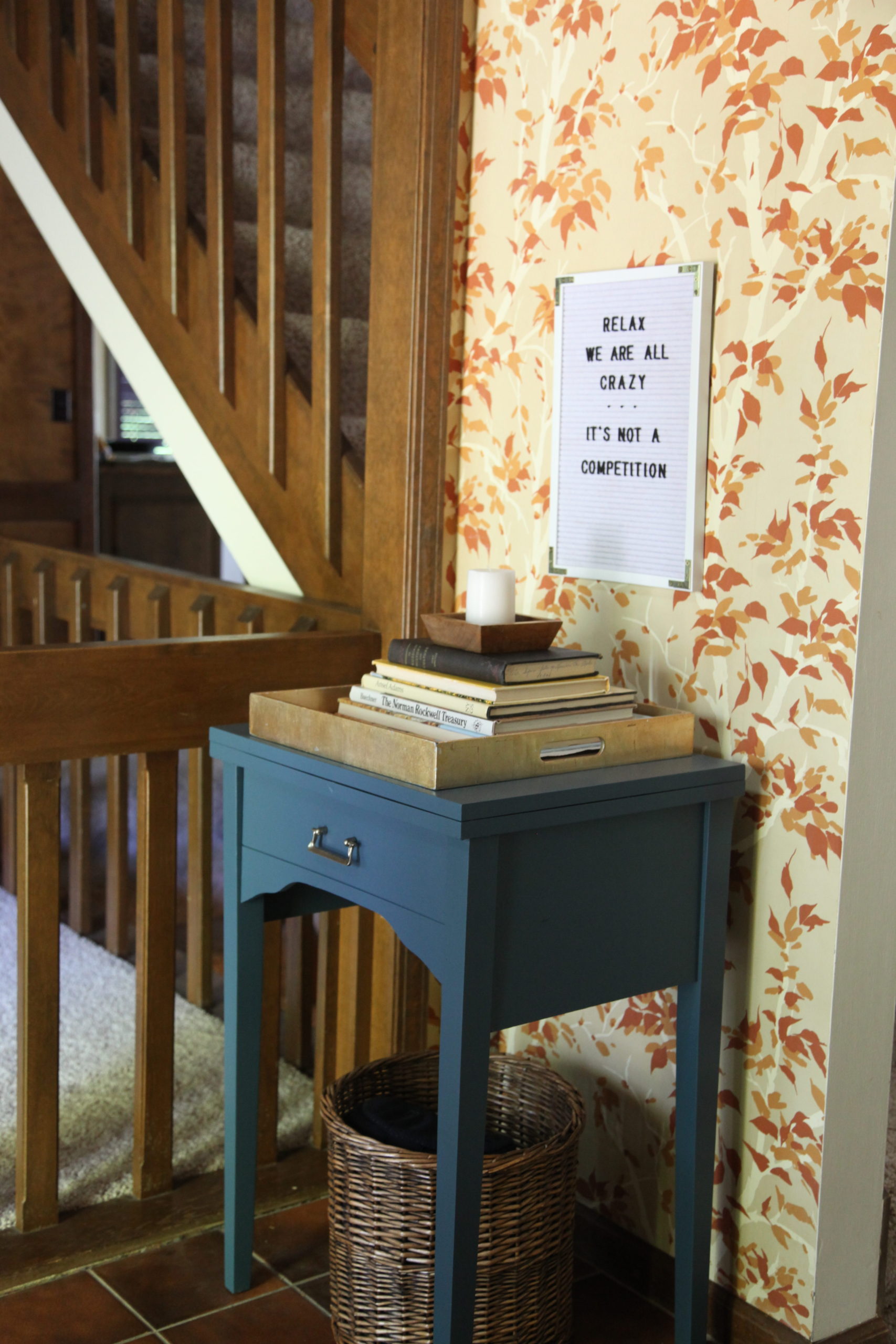 Old sewing table transformed with blue navy paint in a foyer entryway