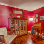 Red sitting room with antique bookcase and secretary